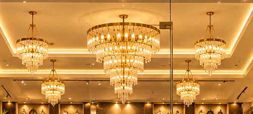 Tiered crystal chandeliers under a coffered, warm-lit ceiling
